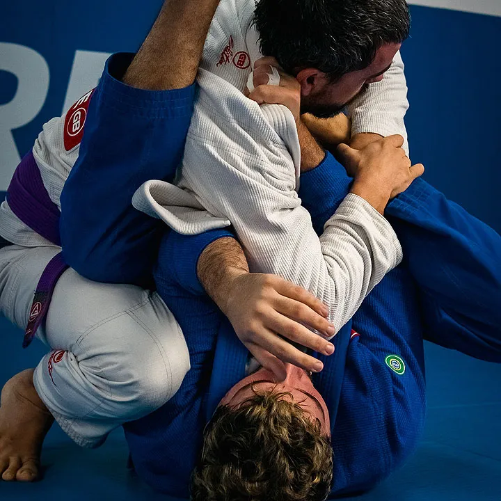 Two adults training Brazilian jiu-jitsu in gis at Glory MMA & Fitness in Lee's Summit