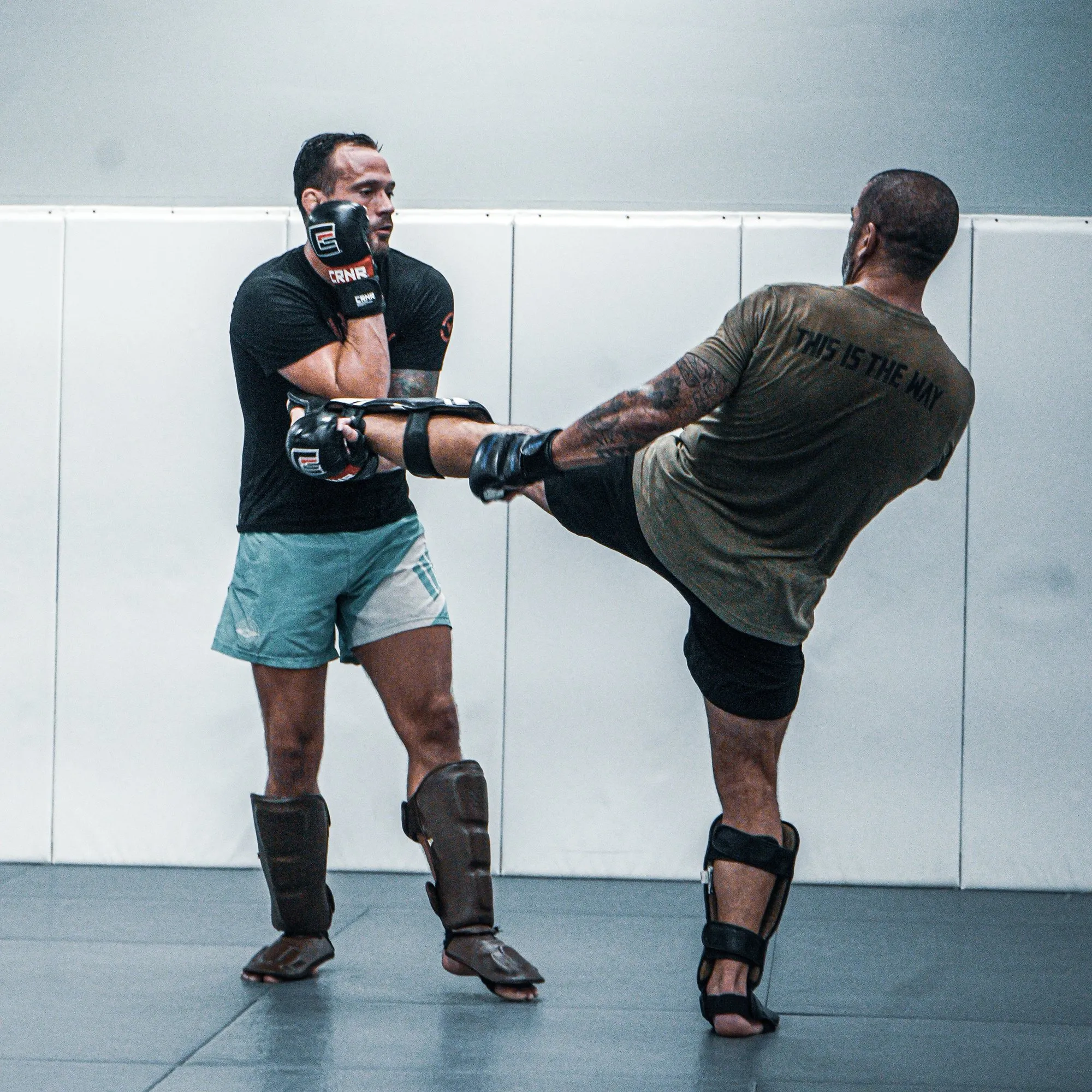 Adults practicing kickboxing with shin guards at Glory MMA & Fitness
